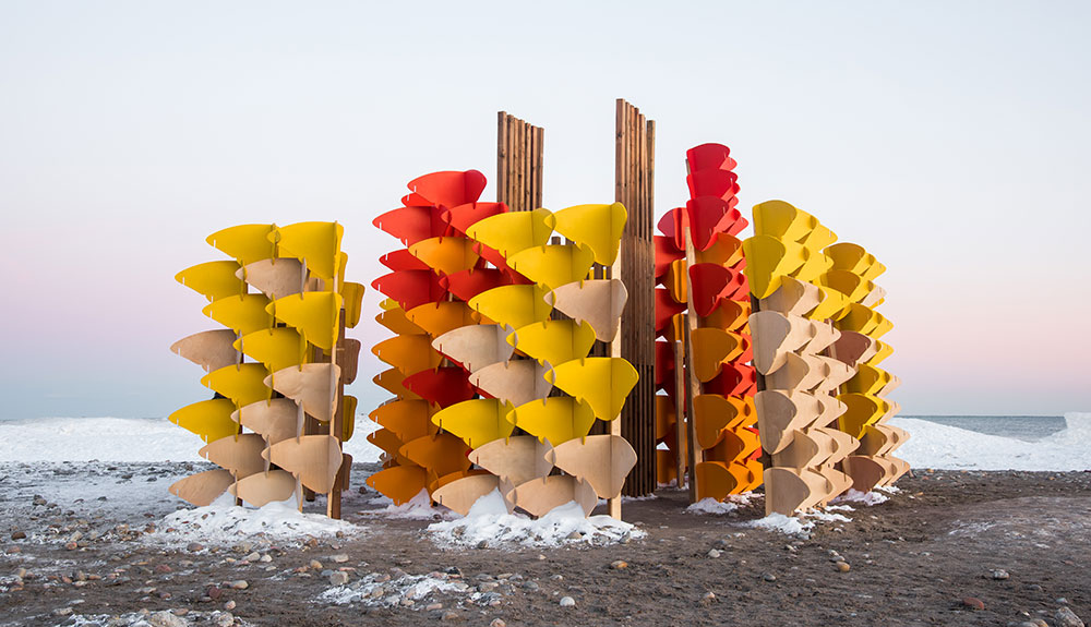 Red, yellow, orange and beige scultures stand on the coast of Woodbine Beach