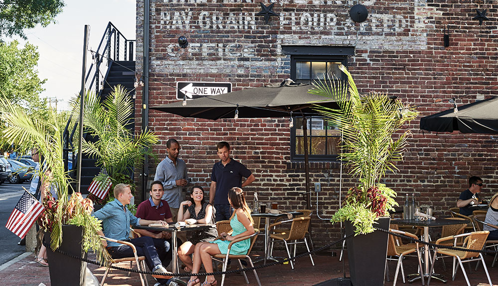 A group sits chatting over dinner on an outdoor patio in Virginia