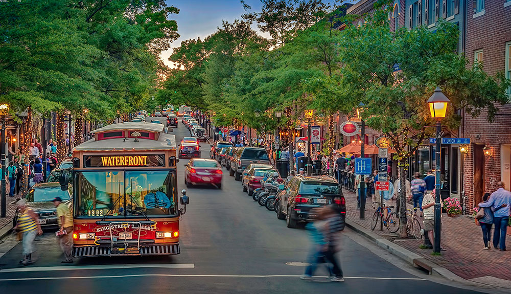 A busy shopping street in Virginia, crowded with people and vehicles