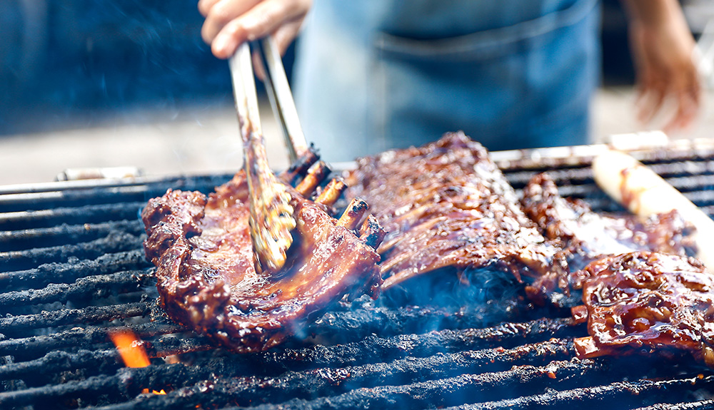 Sauced ribs cooking on hot grill at Toronto RibFest