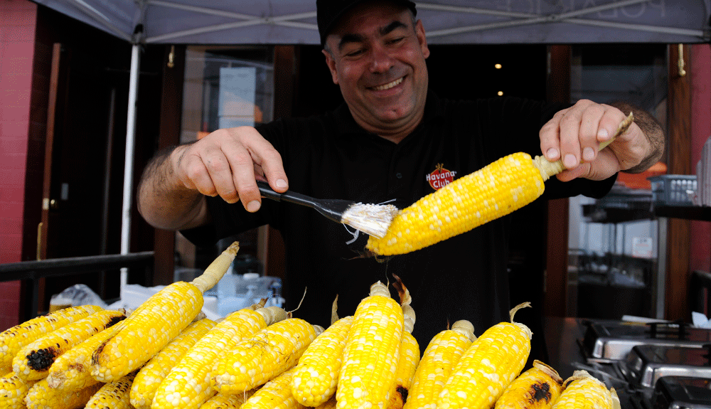 A vendor butters corn on the cob at Taste of the Danforth in Toronto