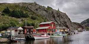 Cute boats and little white, brown and red buildings line the coast of St. John's, Newfoundland