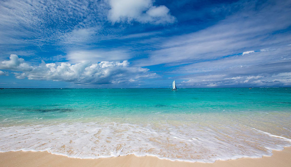 Calm Caribbean waves reach for soft sand from the ocean