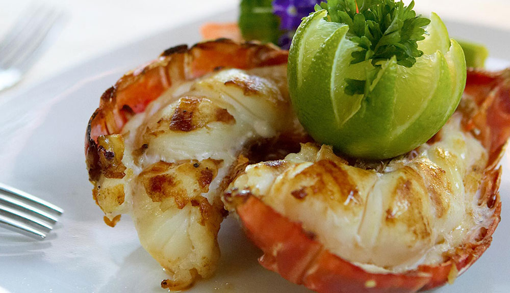 Close up shot of lobster tail with a lime cut into a flower
