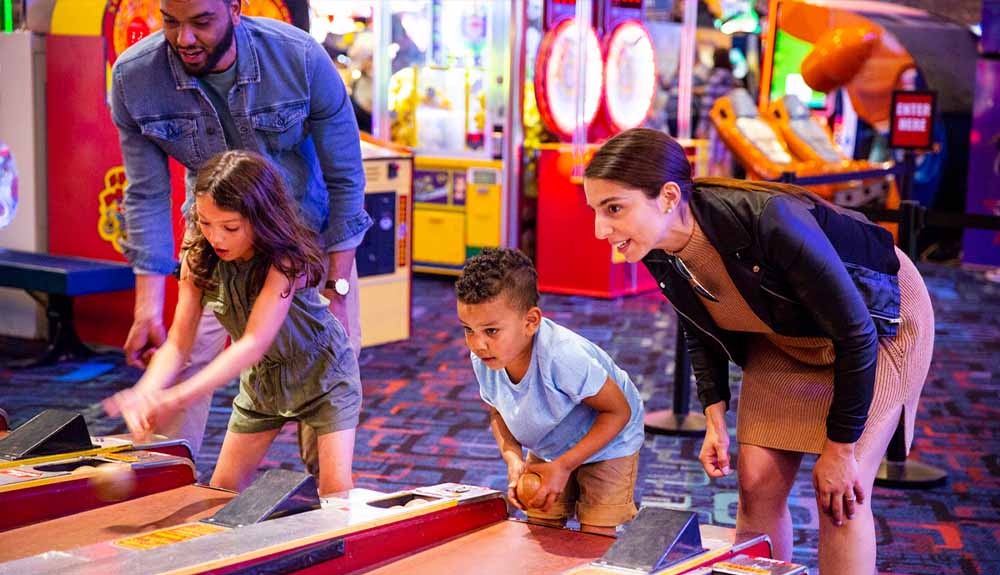 A family plays ski ball at an arcade in the Clifton Hill area of Niagara Falls, Ontario