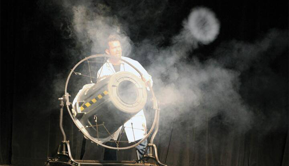 A scientist with a machine shooting smoke.