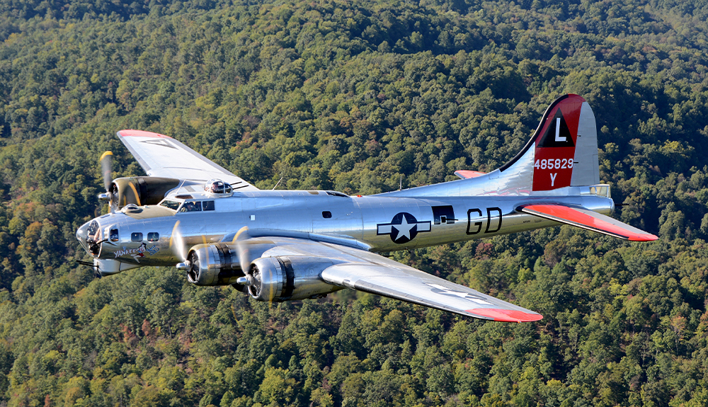 A vintage plane from the Yankee Air Museum flies over the tree line in Ann Arbor, Michigan.