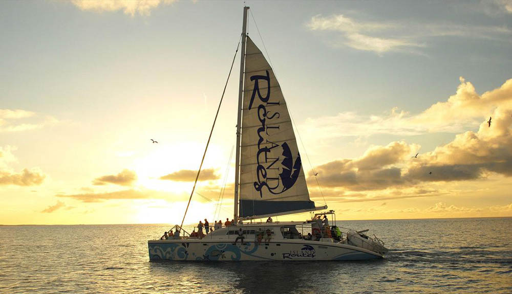 A catamaran sails along the ocean at sunset in Negril, Jamaica