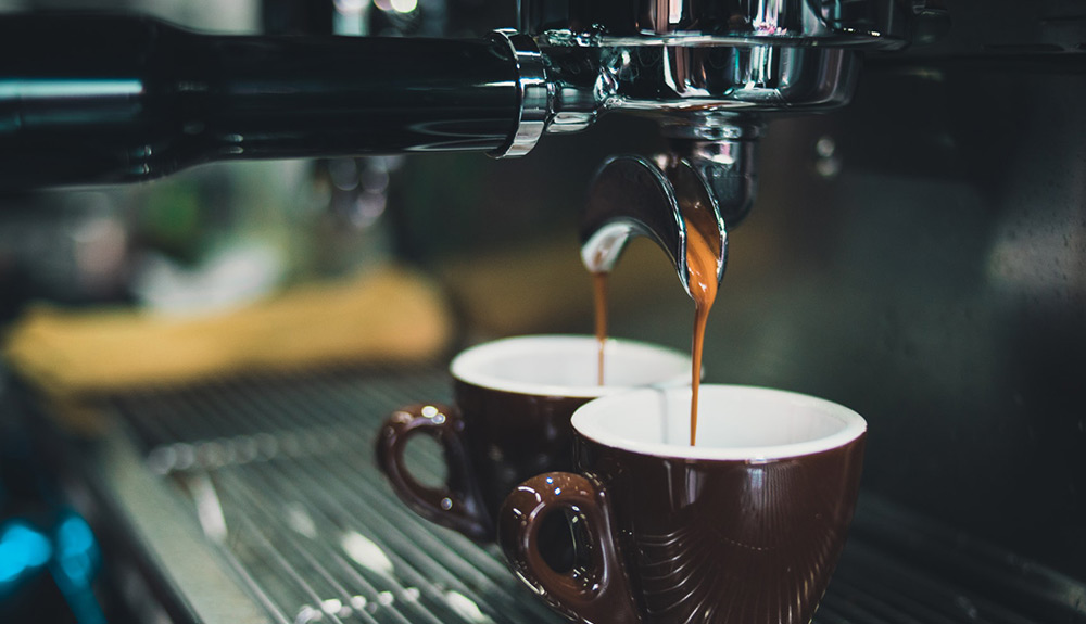 An espresso machine pulls a double shot into two small espresso cup