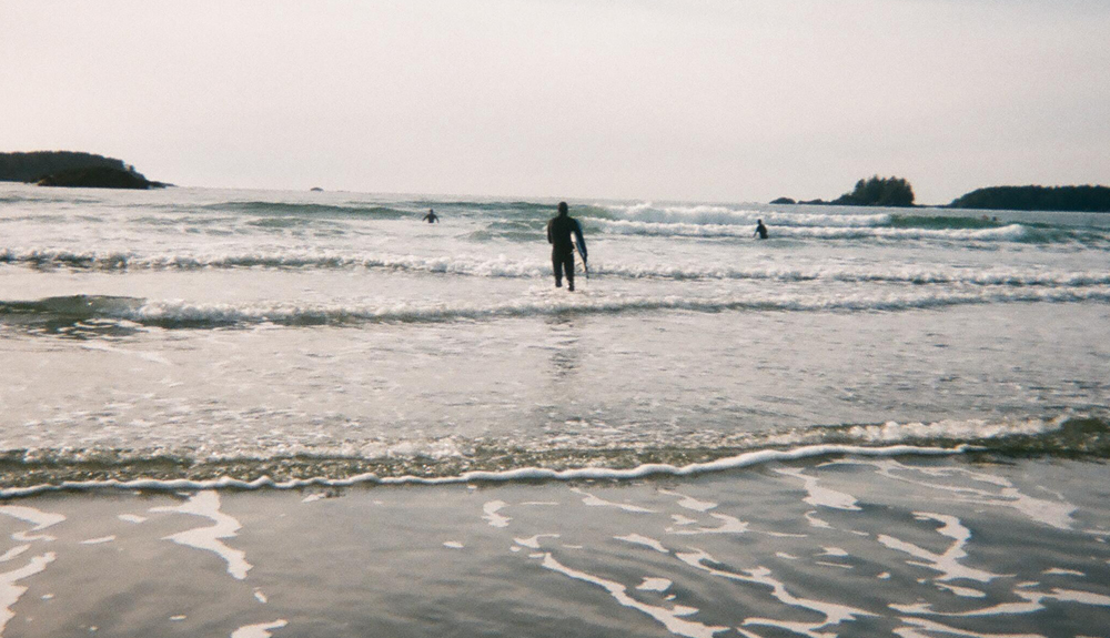 A man on a beach with the surfing board.