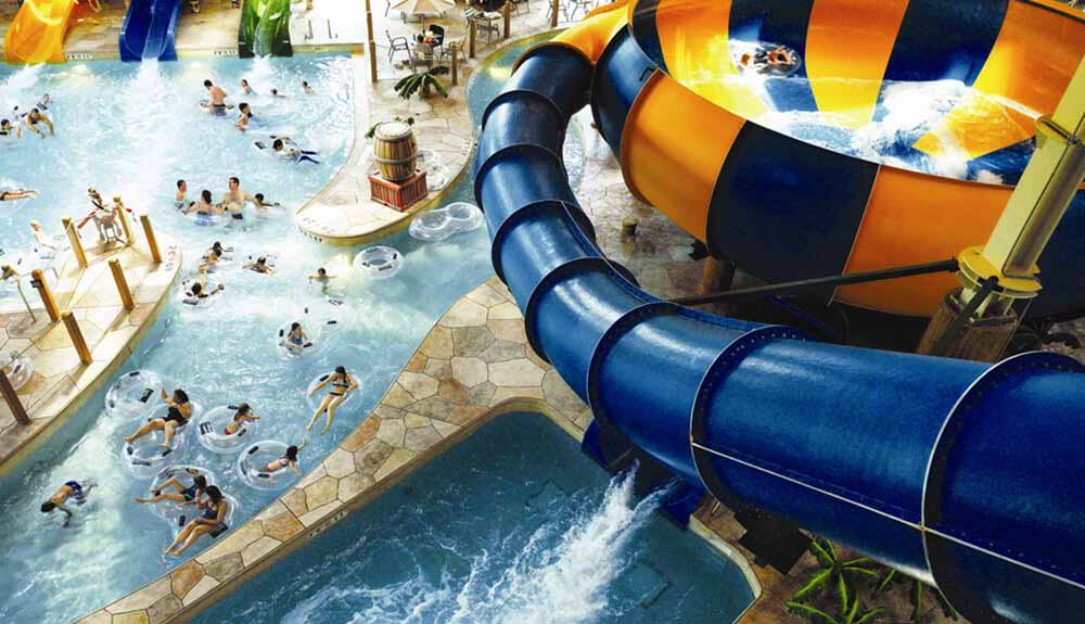Blue waterslide feeds into a funnel of fun with people floating in clear tubes in the pools beneath