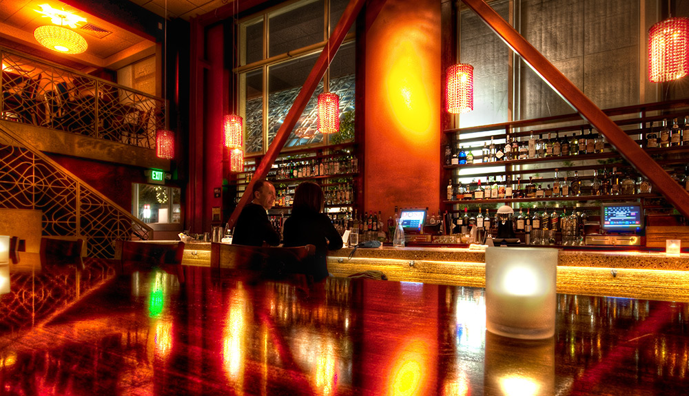A romantic and dimly lit parrilla (steakhouse) lit with candles, a couple standing at the bar