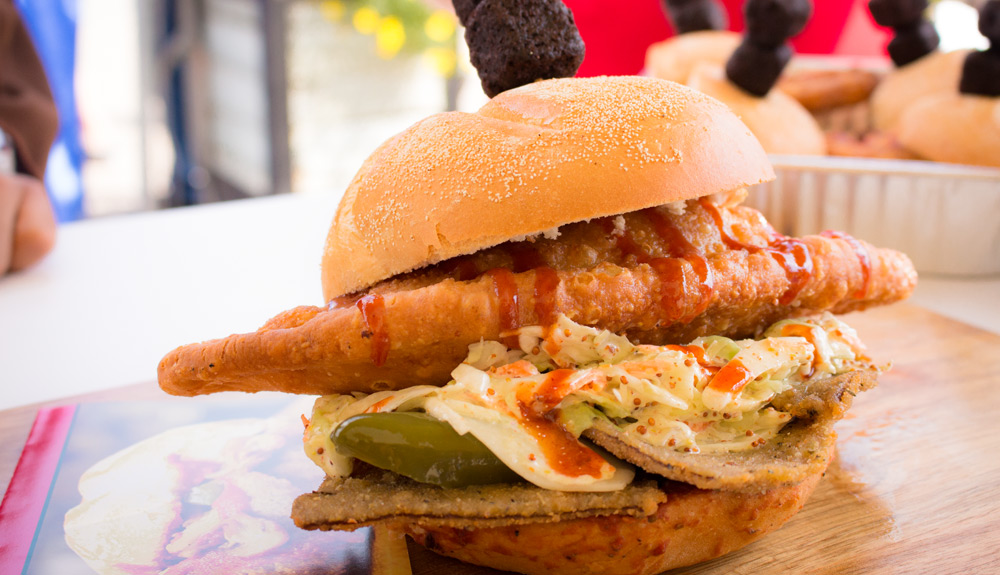 A large sandwich made with pulled pork, veal and topped with a creamy coleslaw, jalapeno peppers and drizzled with a sweet barbecue sauce, as seen at the CNE