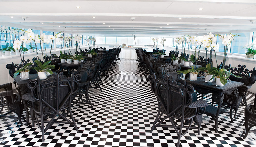 A shot of the empty restaurant featuring black tables and chairs on the top deck of the S.S. Antoinette