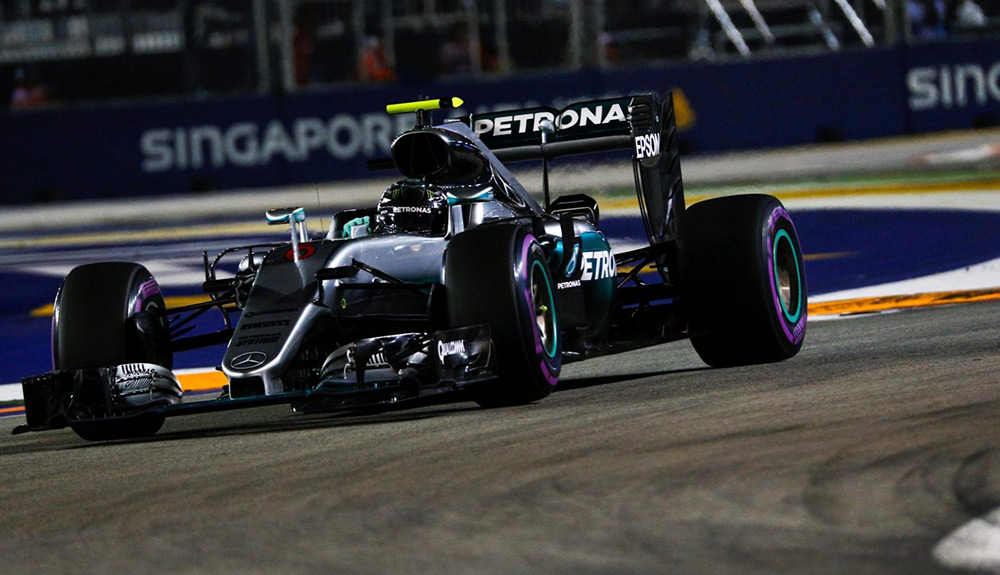 A black Formula 1 car races down a curved track in Marina Bay, Singapore