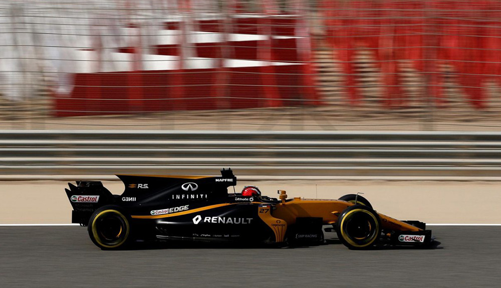 A black Formula 1 race car zooms down a track in Sakhir, Bahrain