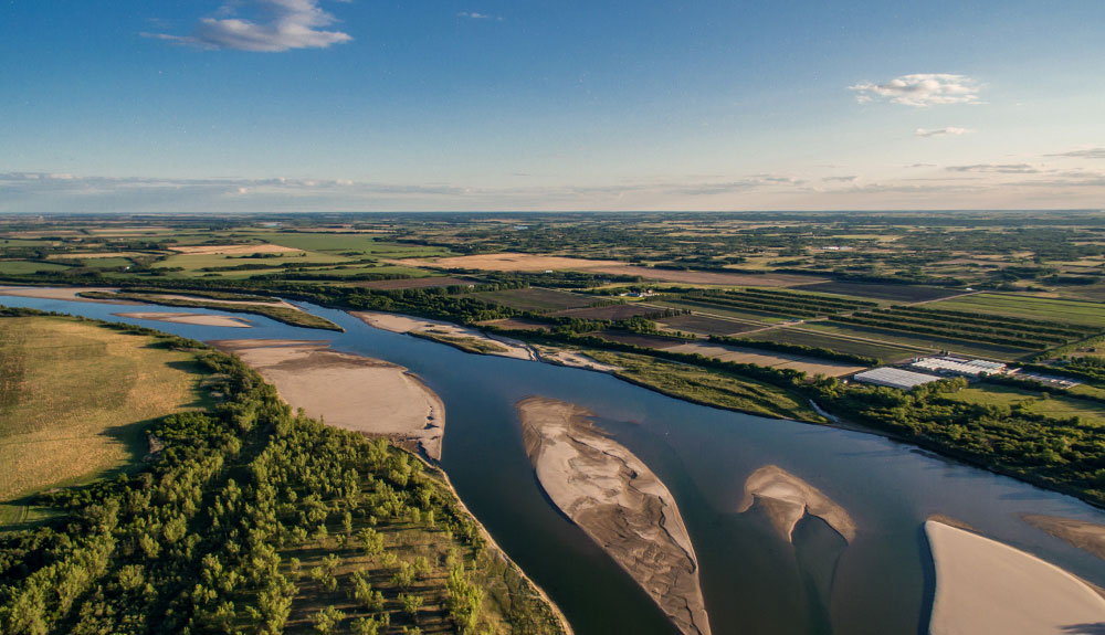 A birds eye view of a stunning Canadian landscape featuring sandy islands in a wide body of water
