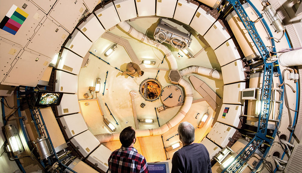 Two men look at a spaceship exhibition at NASA