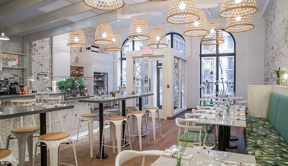 Wicker lampshades, whitewashed brick walls and empty tables at LOV