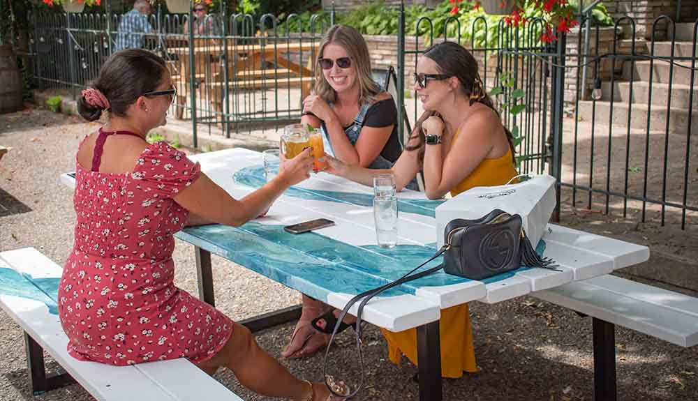 A group of friends are shown eating at a picnic table