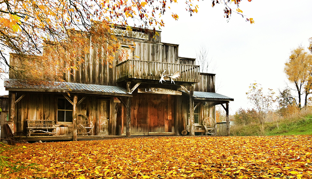 The exterior of a wooden building with a sign at the top that says 'Escape Maze' in Peterborough