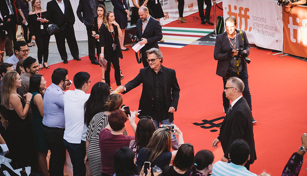 Celebrities walk the red carpet at TIFF with fans reaching from the crowd