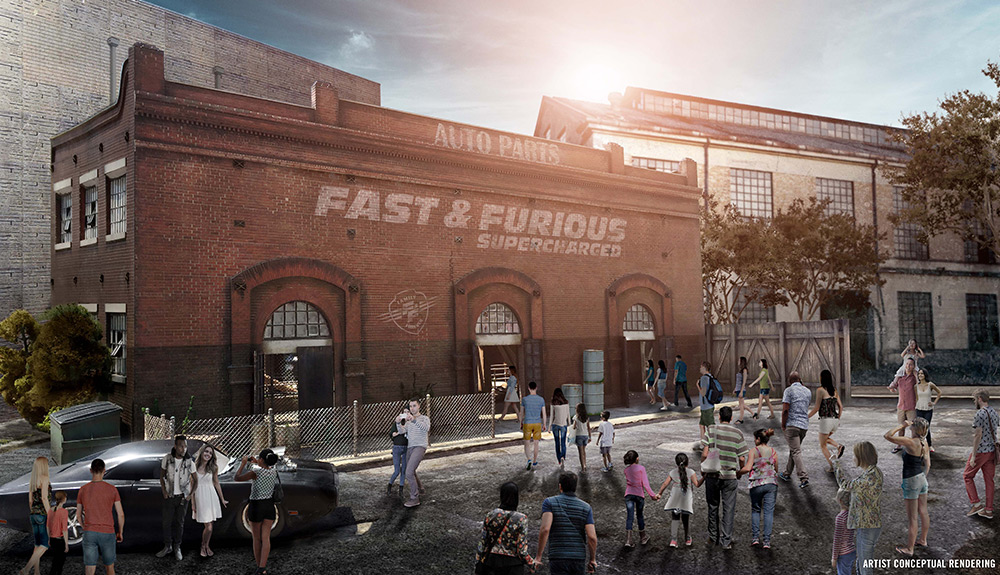 A crowd mills about a building that advertises the Fast and Furious film, a car from the film is seen outside and tourists take pictures of it