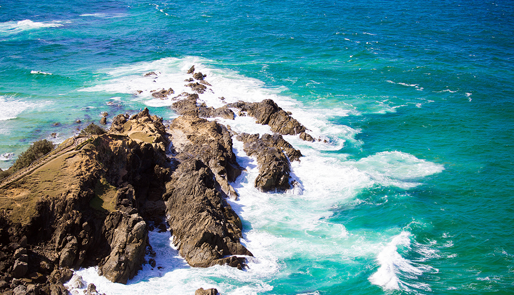 Photo submitted by Akshay Kumar of the rocky shoreline, waves splashing at the easternmost point of Australia