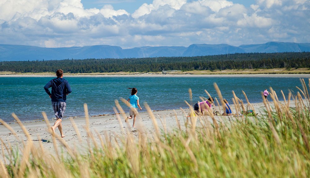 A man and child run along the coast at Rocky Harbour
