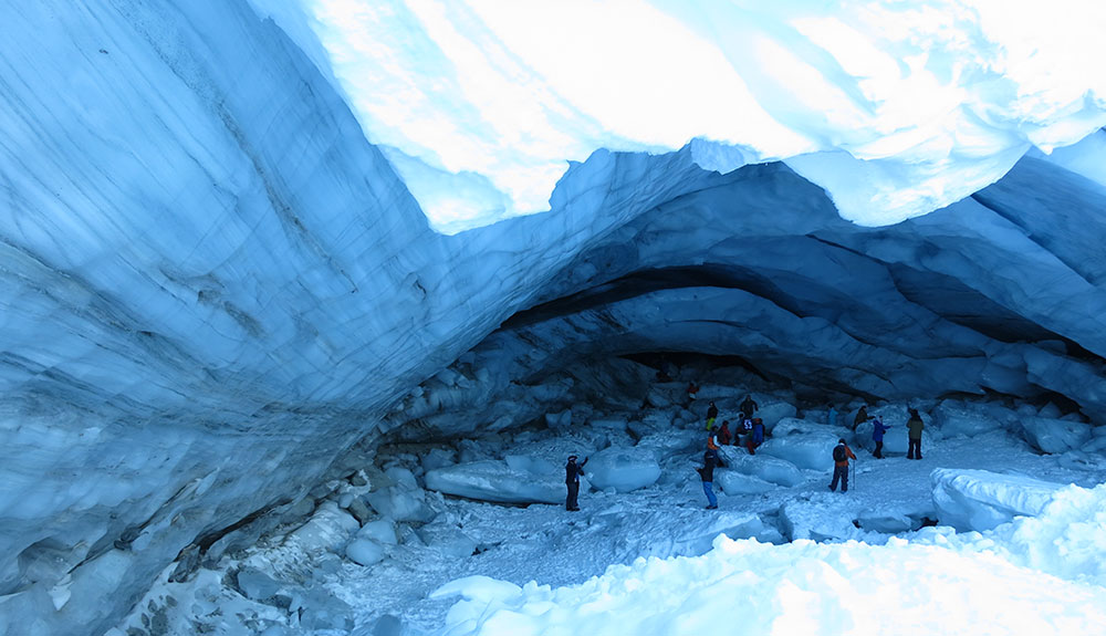 People exploring ice fields in a cave
