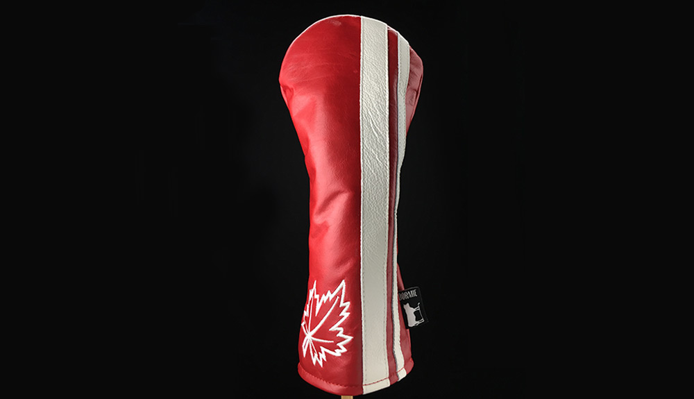 Product shot of red and white Dormie headcovers with maple leaf on black background