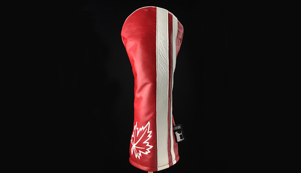 Product shot of red and white Dormie headcovers with maple leaf on black background