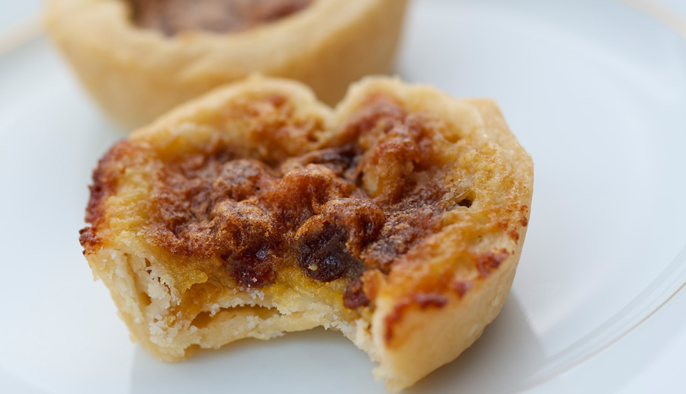 Closeup shot of butter tart with a single bite out of it