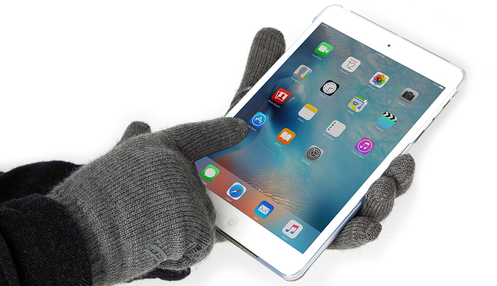 An Apple ipad is seen, with a gloved hand wearing Moshi Digits gloves in grey tapping on an app icon