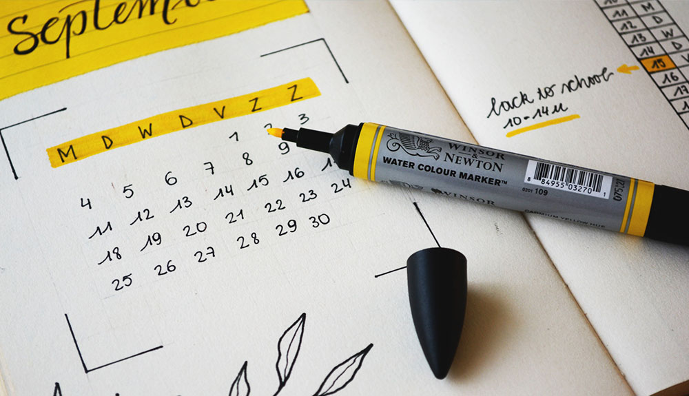 A calendar in a planner with a highlighter opened to Semptemberl