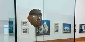 A mask is shown in a gallery with paintings in the background