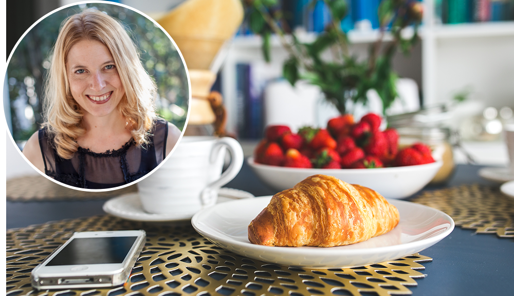 A headshot of author Laura Vanderkam transposed over a photo of a breakfast table, phone, croissant, mug of coffee and a large bowl of fresh strawberries are seen on the table