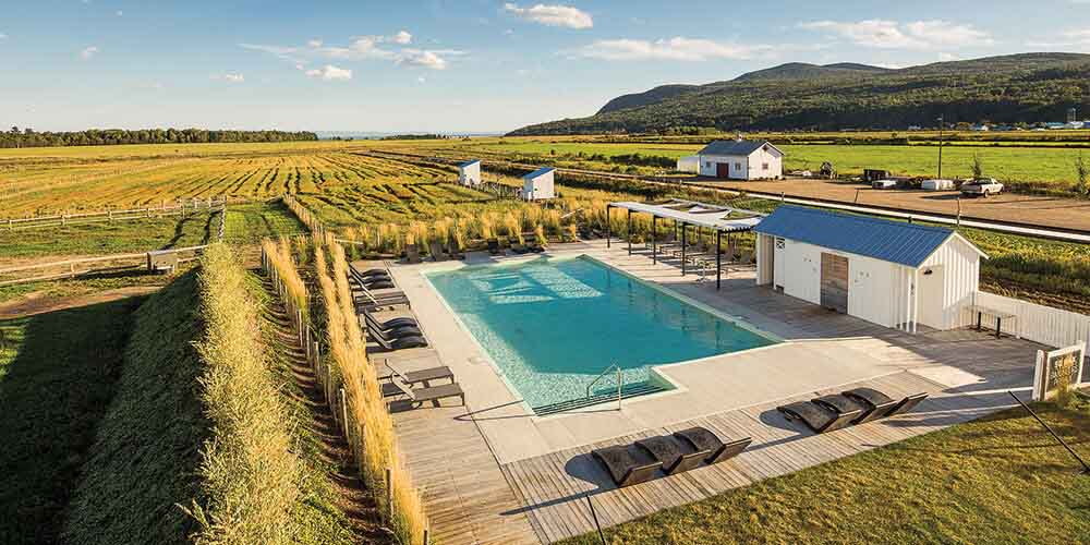 The outdoor pool at Le Germain Charlevoix Hotel and Spa in Quebec surrounded by farmland