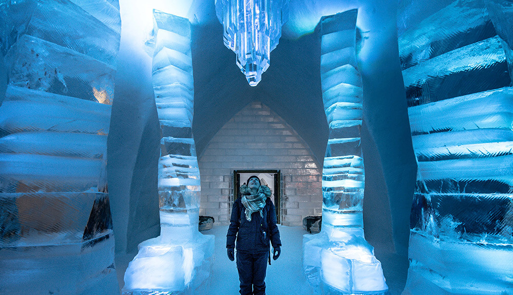 A man gazes in awe at the icy ceiling at the Hotel de Glace in Quebec