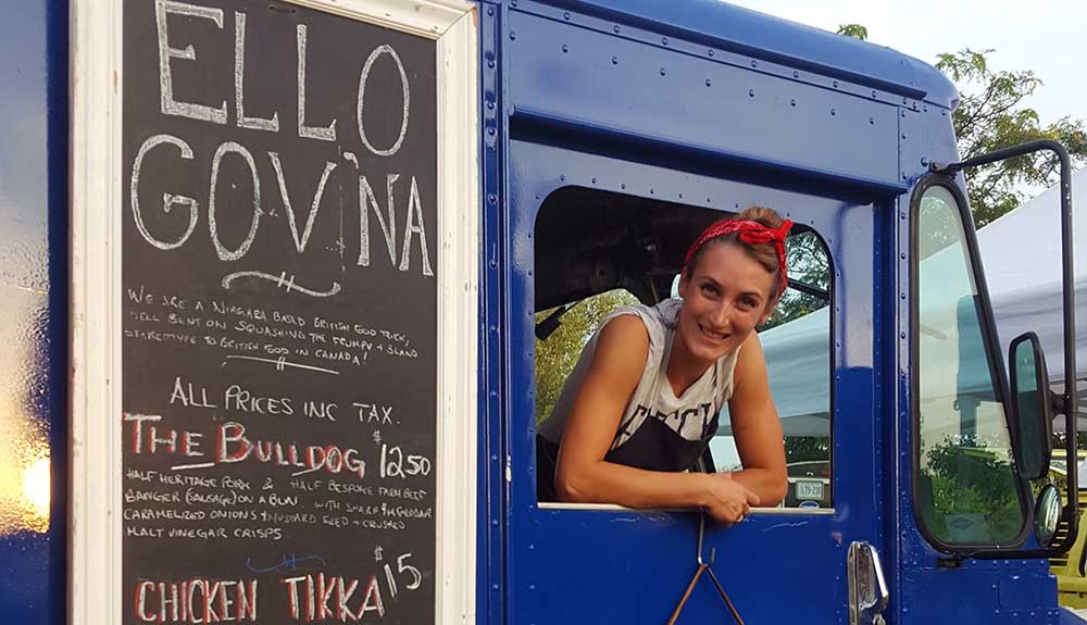 A woman leans out the window of the Ello Gov'na food truck in Niagara