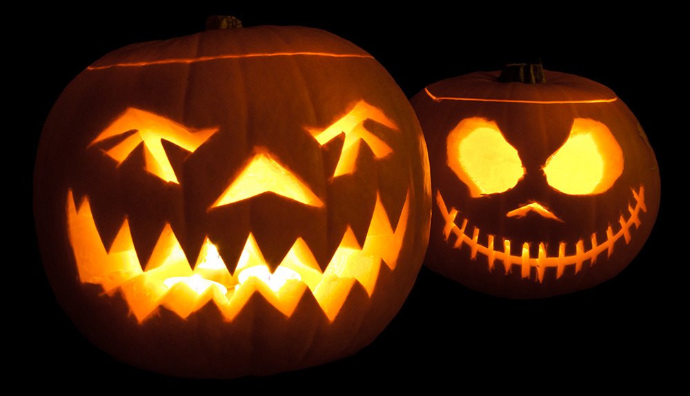 Two Jack-o-Lanterns, carved with spooky faces and lit up with candles