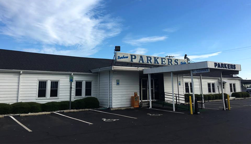 The exterior of Parker's BBQ joint is seen, large signs proclaiming the name of the restaurant