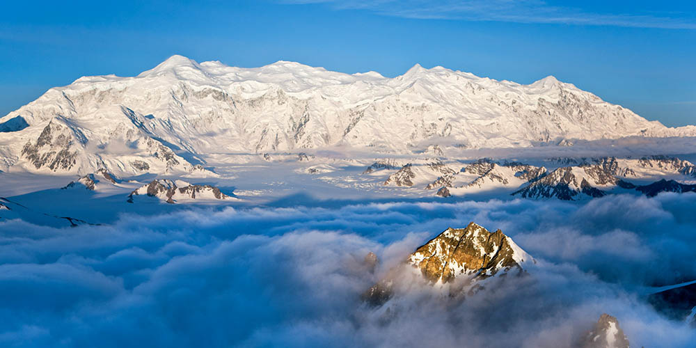 Beautiful snow-covered mountains high in the sky amongst the clouds