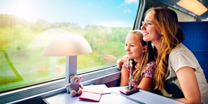 Mother and daughter looking out train window