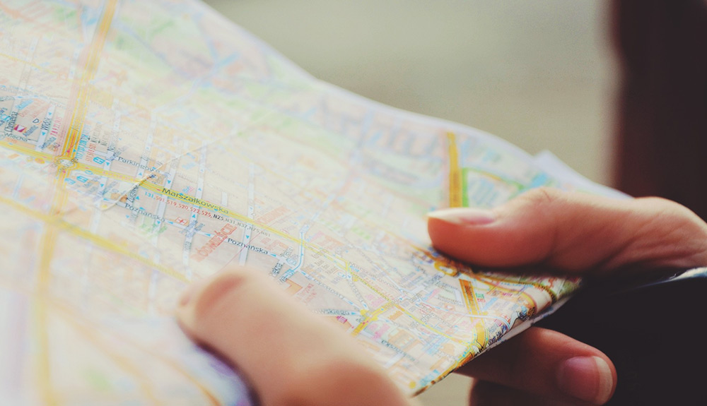 Hands hold a folded paper map