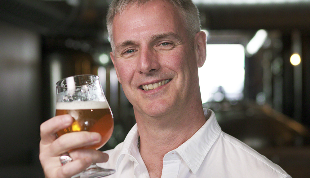Stephen Beaumont holding a bruges beer glass filled with beer