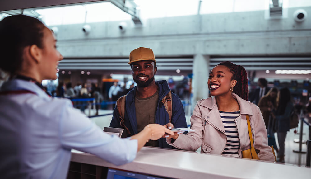 Couple showing boarding pass at airport check-in counter