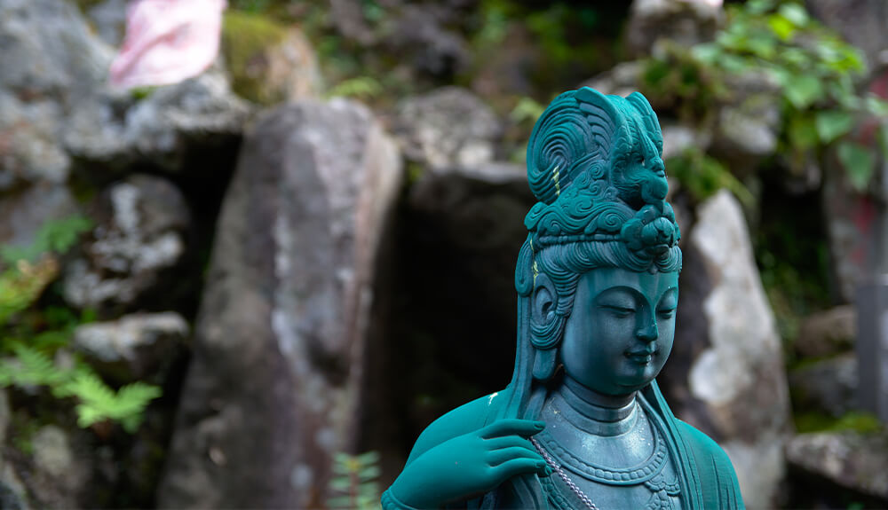 Weathered bronze Buddha statue in the Japanese spa town of Kinosaki