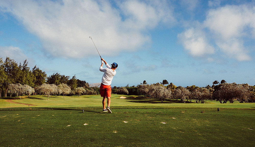 The back of someone swinging a golf club