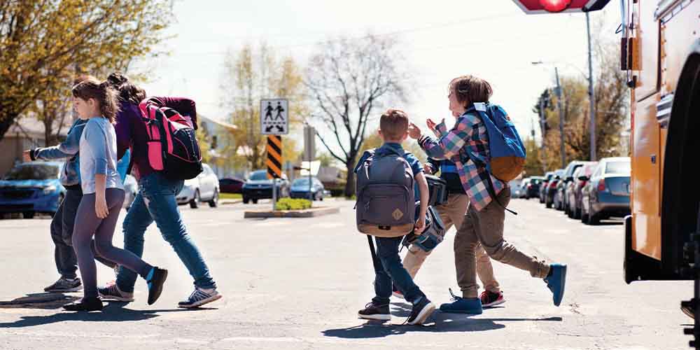 Children crossing the street in autumn
